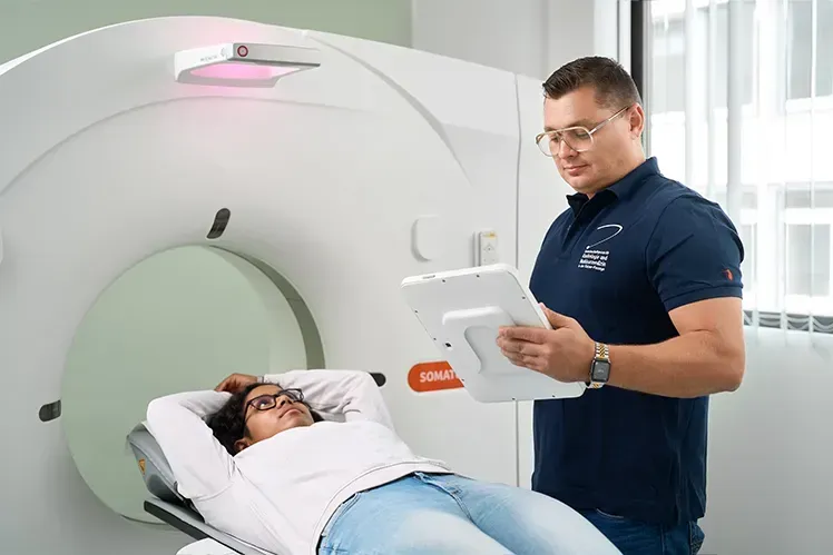 Medizinischer Mitarbeiter der Gemeinschaftspraxis für Radiologie und Nuklearmedizin in der Kaiser-Passage, Bonn bereitet eine Patientin auf die Computertomographie vor.